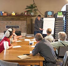 people in meeting with leader at whiteboard